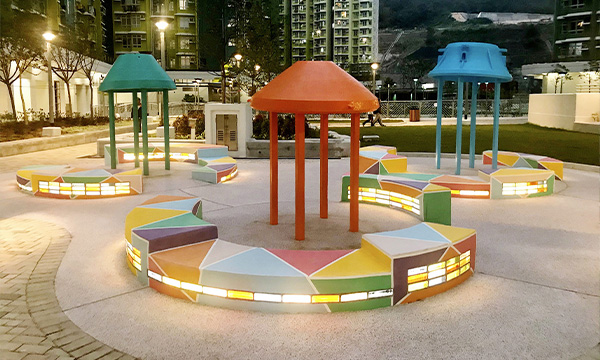 The artwork in On Tai Estate entitled “Embrace My Room” is a replica of a primitive man's hut. The old machinery parts have been transformed into a public art space with colourful glass blocks.